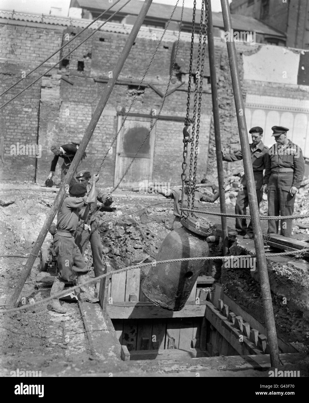 Des hommes de l'unité d'élimination de la bombe n° 2 transportent une bombe allemande de 2,500 hors du sol sous un bâtiment partiellement démoli au large de Tottenham court Road. Banque D'Images