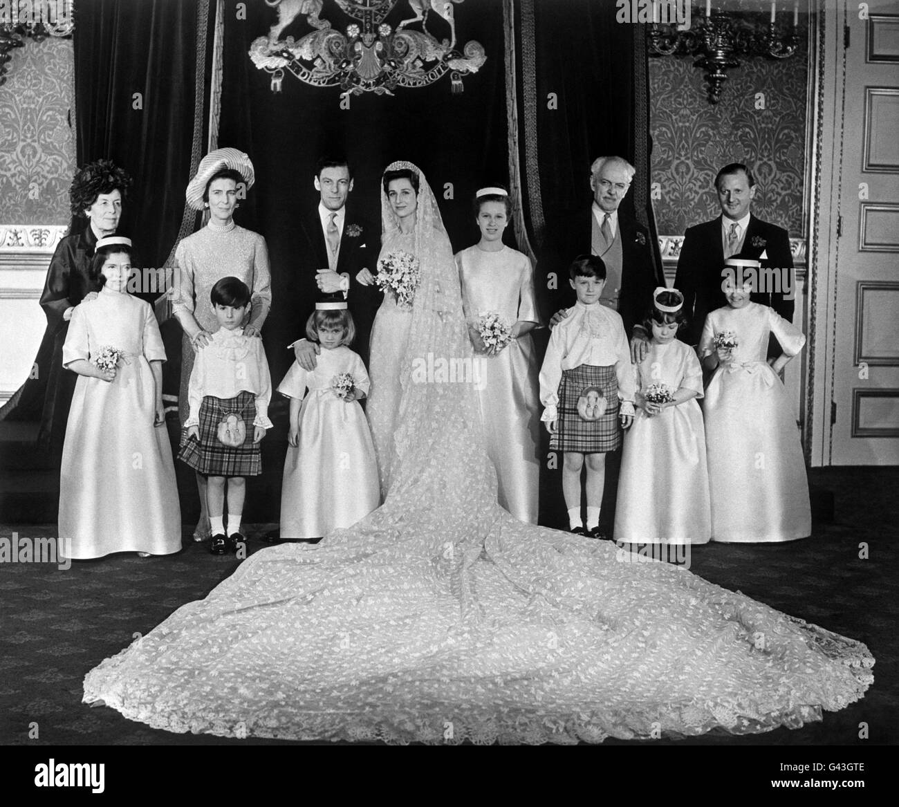 Le groupe de mariage au Palais St James's, à Londres, lors de la réception suivant le mariage de la princesse Alexandra et d'Angus Ogilvy. De gauche à droite, rangée arrière; la comtesse d'Airlie (mère de l'époux), la princesse Marina, la duchesse de Kent (mère de la mariée), la mariée et le marié, la princesse Anne, le père du marié, le comte d'Airlie, et Peregrine Fairfax. Première rangée, à partir de la gauche; Doune Ogilvy, David Ogilvy, Élisabeth d'Autriche, Simon Hay, Georgina Butter et Emma Tennant. Banque D'Images