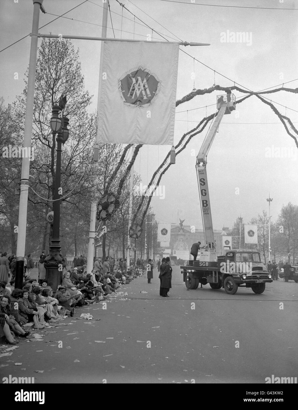 Les ouvriers du centre commercial, qui exploitent un ascenseur mobile, préparent la Rose Arch des décorations de mariage royal pour la princesse Margaret épouse Antony Armstrong-Jones Banque D'Images