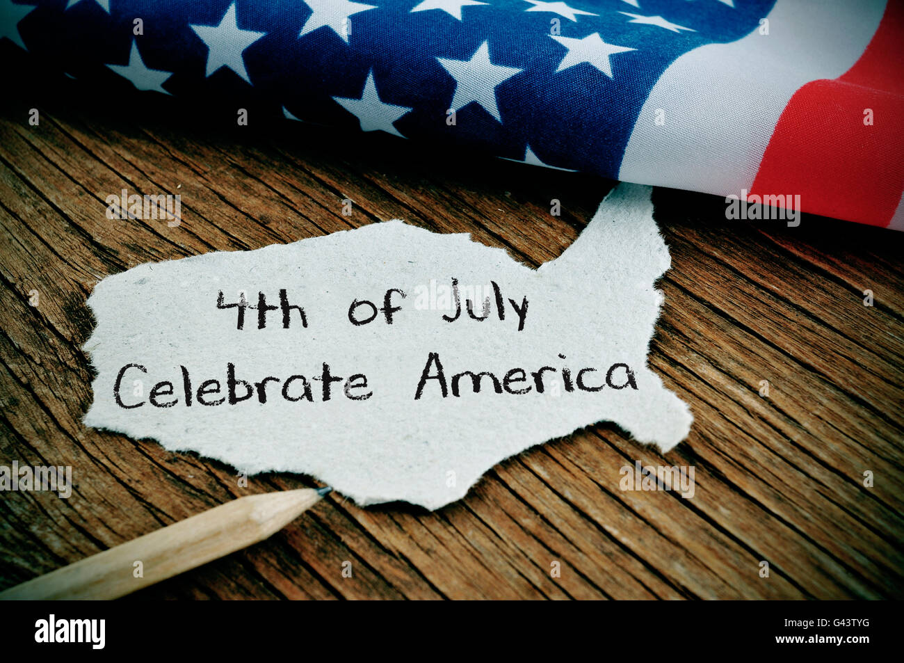 Un morceau de papier en forme de la United States avec le texte 4 juillet célébrer Nord écrit en C, sur un sol en bois rustique Banque D'Images