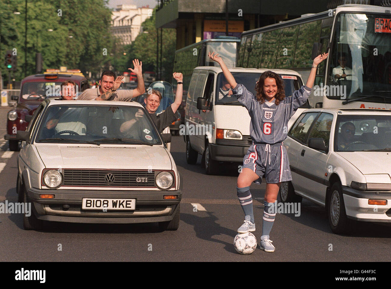 Emma Kilbey, une volontaire de la FA portant les couleurs de la réserve d'Angleterre, met le trafic à l'arrêt dans le Lancaster Gate de Londres après le dessin déterminant les kits à porter par l'Allemagne et l'Angleterre lors de leur demi-finale Euro '96. Photo de David Cheskin/PA. Banque D'Images