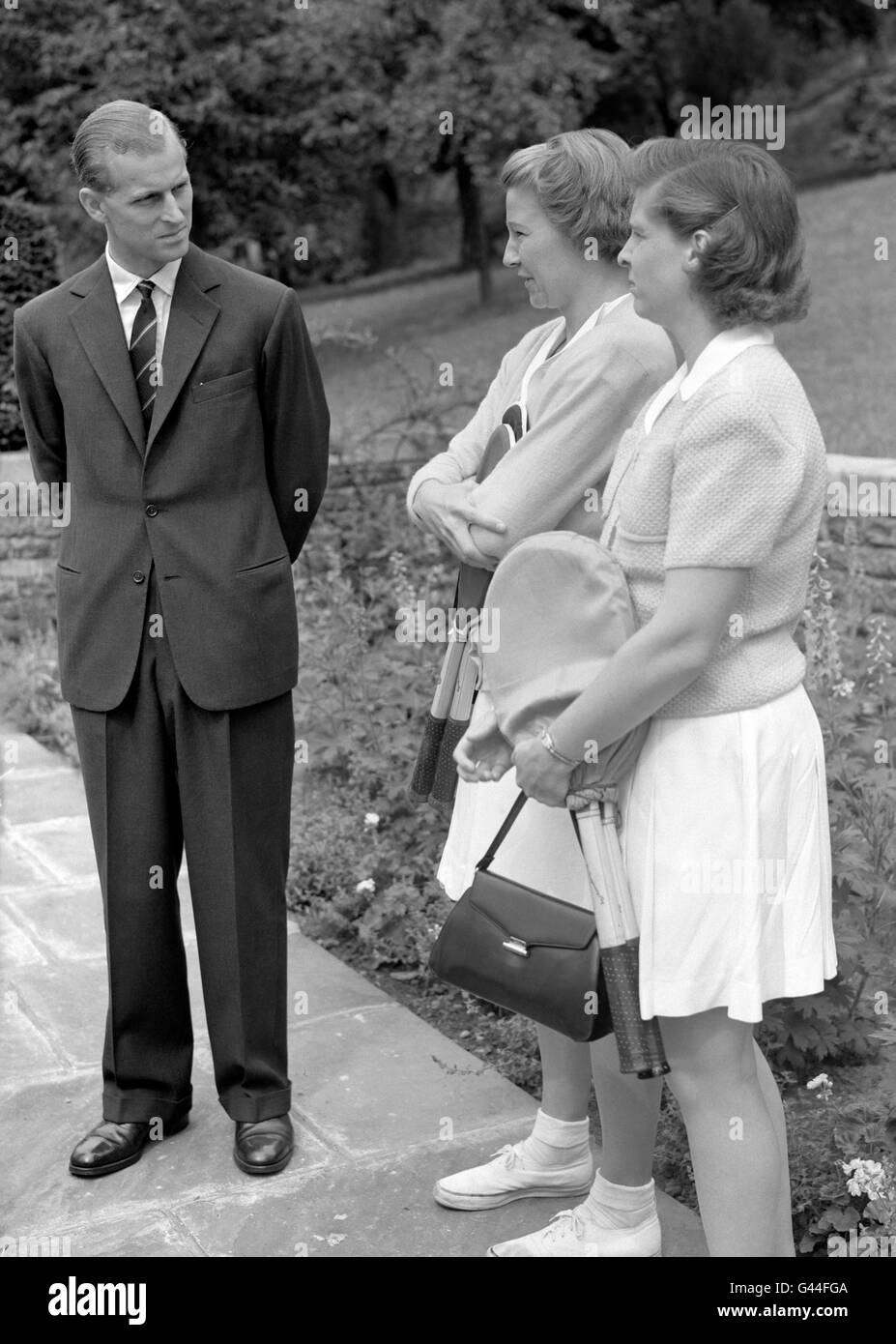 Le duc d'Édimbourg a eu une conversation avec Louise Brough et Margaret du Pont, joueurs de tennis américains, lorsqu'il était invité à la fête avant Wimbledon de Lady Crossfield, qui a eu lieu chez elle à Highgate (nord de Londres). Banque D'Images