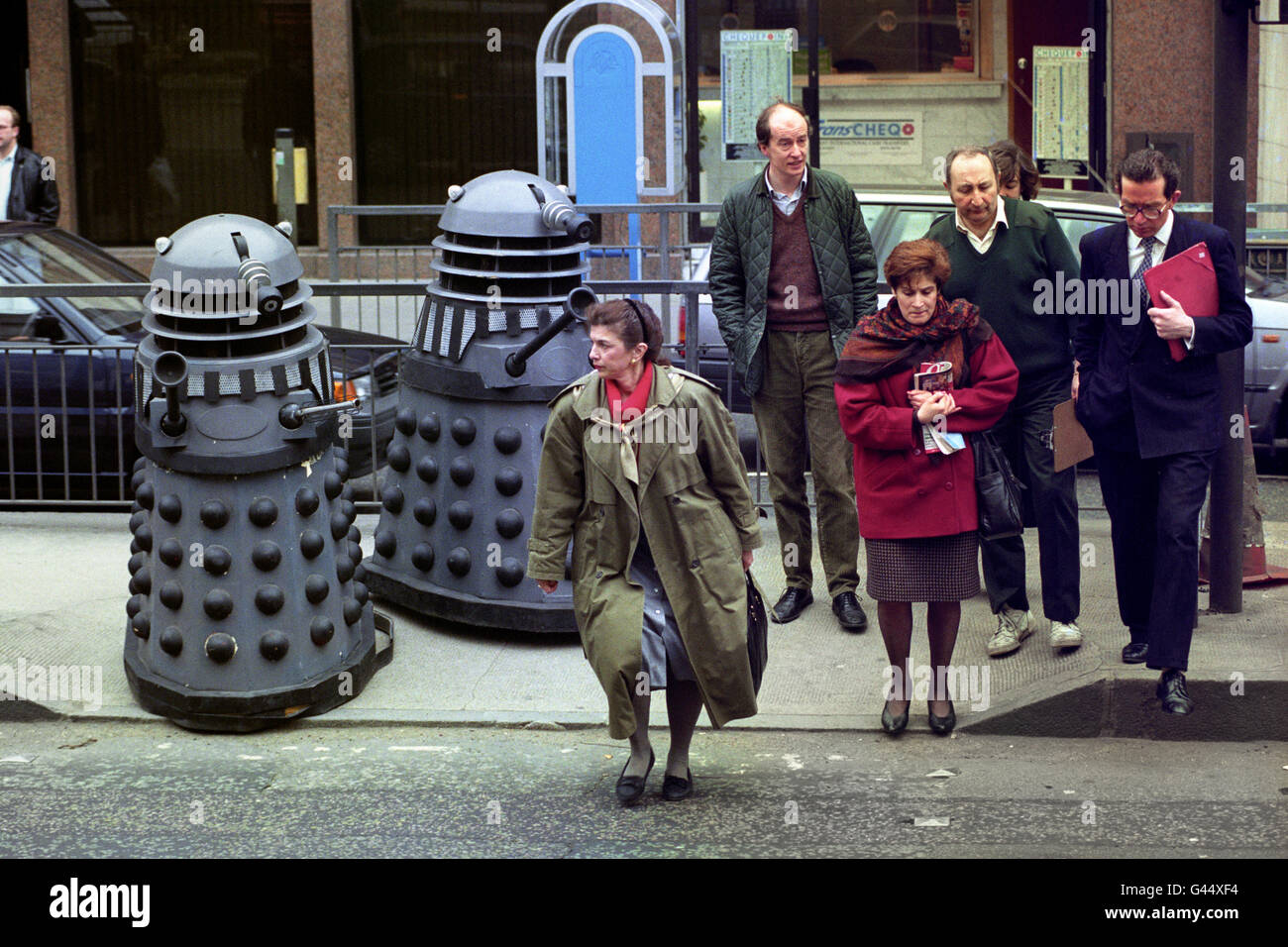 Deux Daleks du Dr Who célébrité, attendez le bon moment pour traverser Montpellier Street, Knightsbridge, Londres, sur leur chemin à Bonhams salle de vente aux enchères, où ils seront en vente avec d'autres souvenirs du Dr Who. Banque D'Images