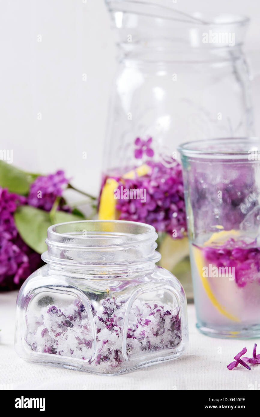 Pot en verre de fleurs lilas en sucre, verre et carafe d'eau lilas avec  citron et branche de lilas blanc frais sur le linge tablec Photo Stock -  Alamy