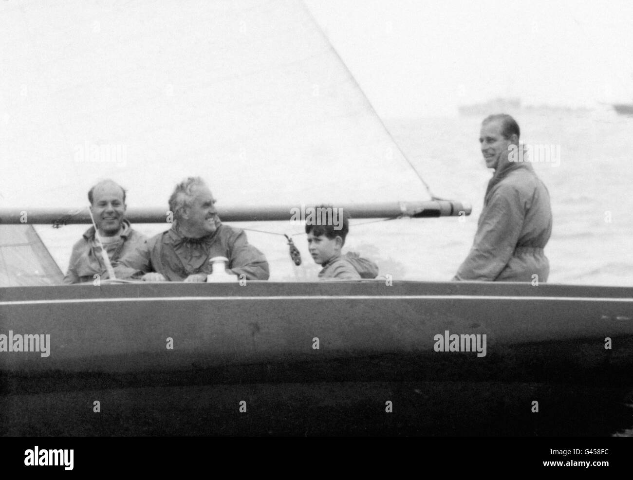Le Prince Charles à bord du yacht de la classe Dragon Bluebottle, avec son père, le duc d'Édimbourg, le lieutenant-commandant Alastair Easton, extrême gauche, et le yachtsman UfFA Fox. Banque D'Images