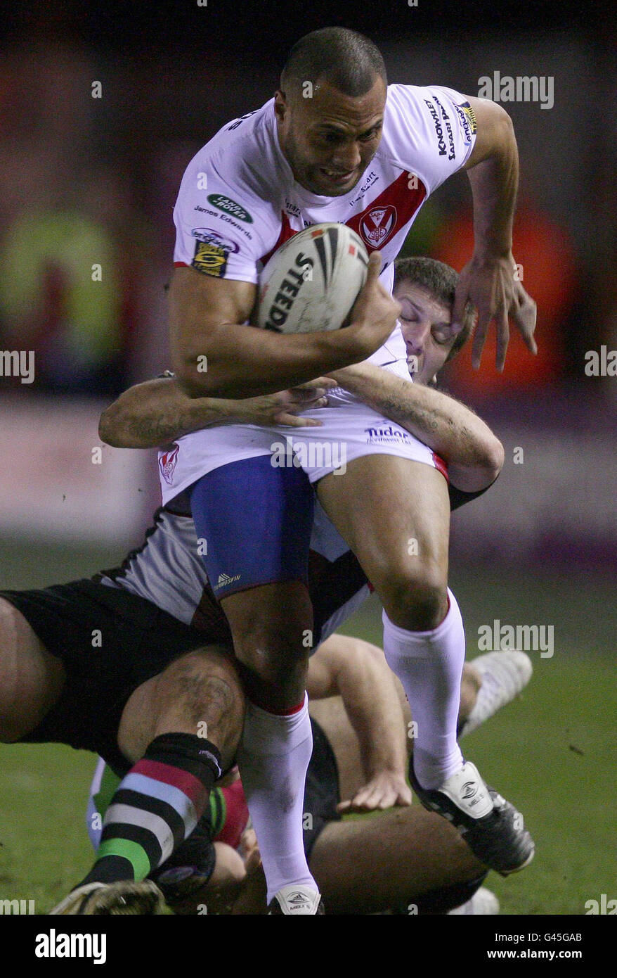 Francis Meli de St Helens est hit par Tony Clubb de Harlequins lors du match de la Super League engage au Stobart Stadium, à Halton. Banque D'Images