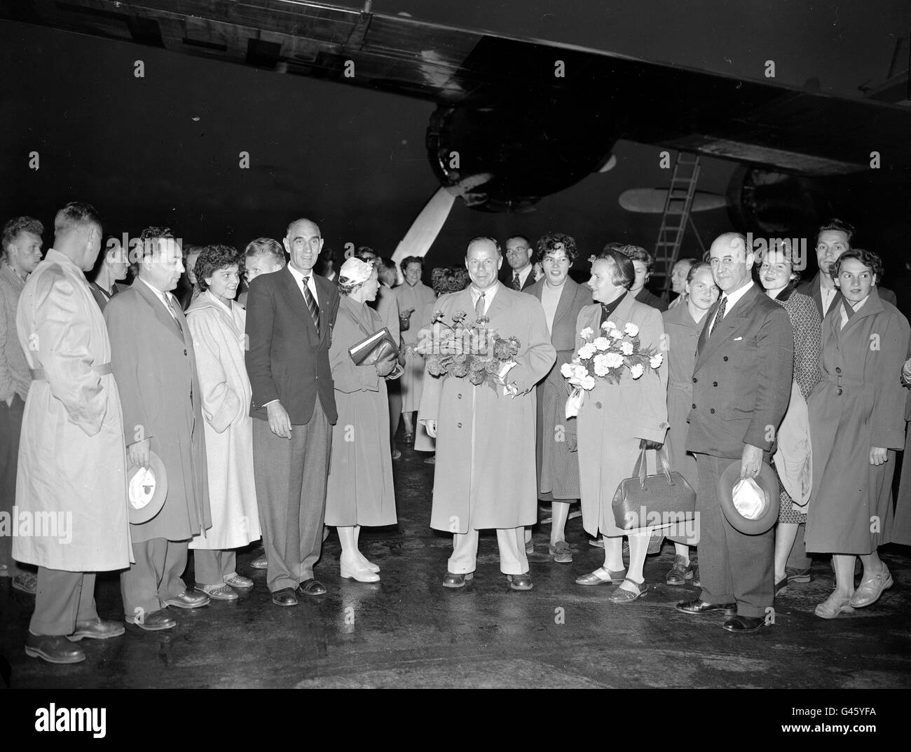 Des hommes et des femmes de l'équipe d'athlétisme russe affronteront la Grande-Bretagne au stade White City à leur arrivée à l'aéroport de Londres.Jack Crump (troisième homme de gauche, cravate rayée), secrétaire du British amateur Athletics Board, est là pour les saluer Banque D'Images