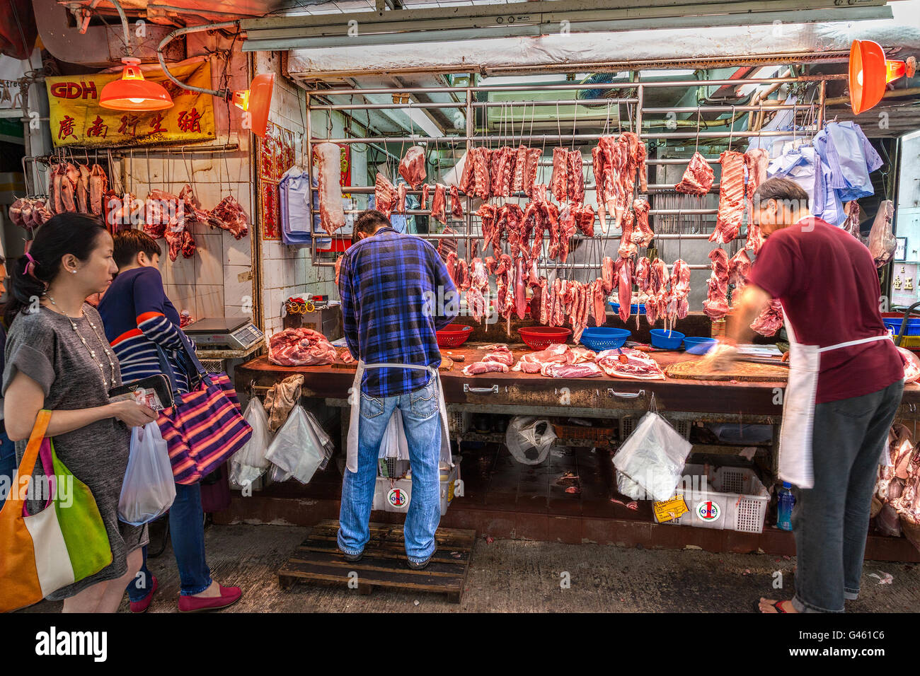 Hong Kong, Chine - le 30 mars 2015 : les bouchers découper le porc en vente sur gage Street dans le quartier central du centre-ville de Hong Kong. Banque D'Images
