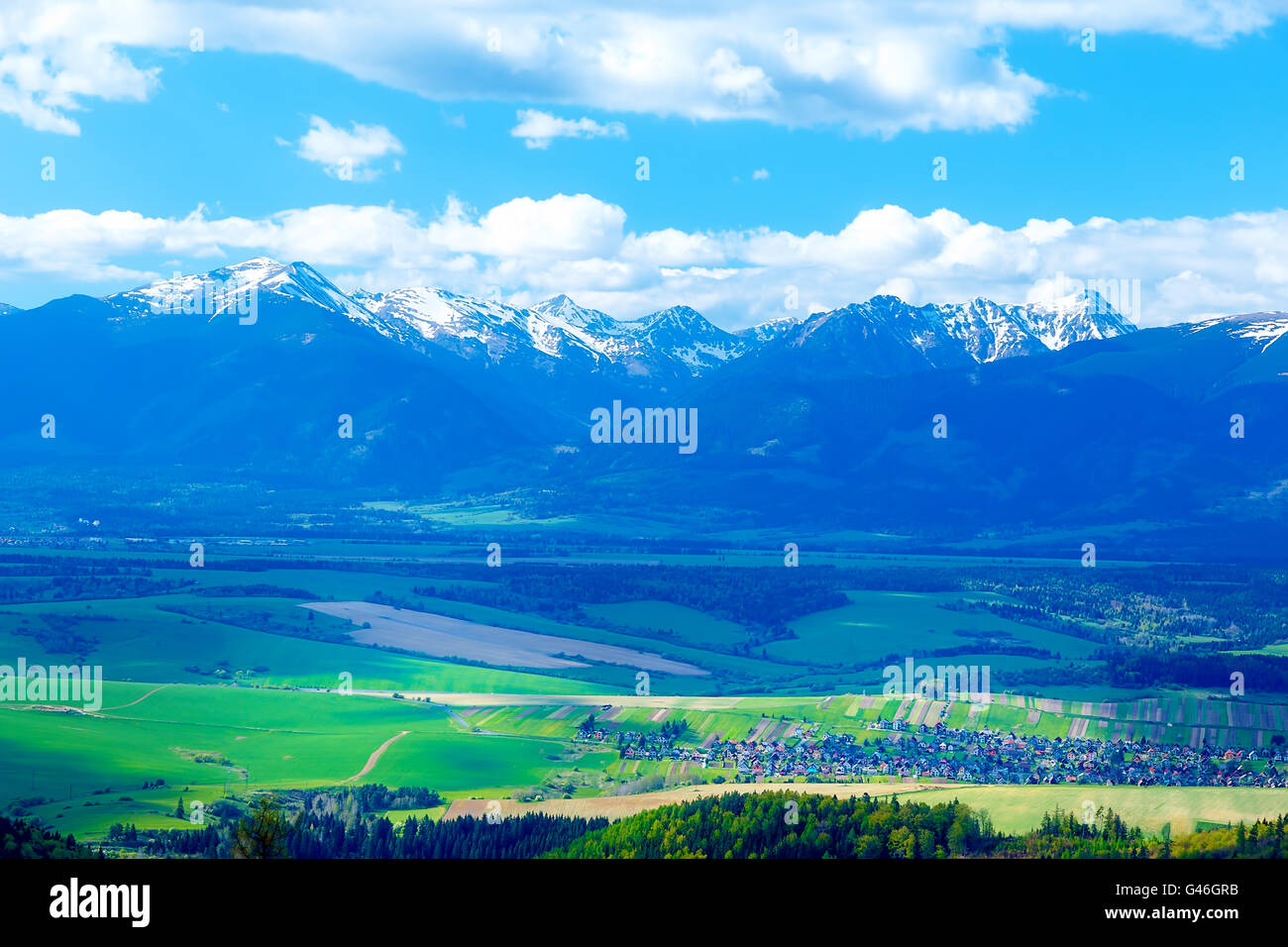 Beau paysage, vert et jaune prairie avec terrain et la neige sur la montagne et le village. La Slovaquie, de l'Europe centrale, de Liptov. Mountain High Tatry. Banque D'Images