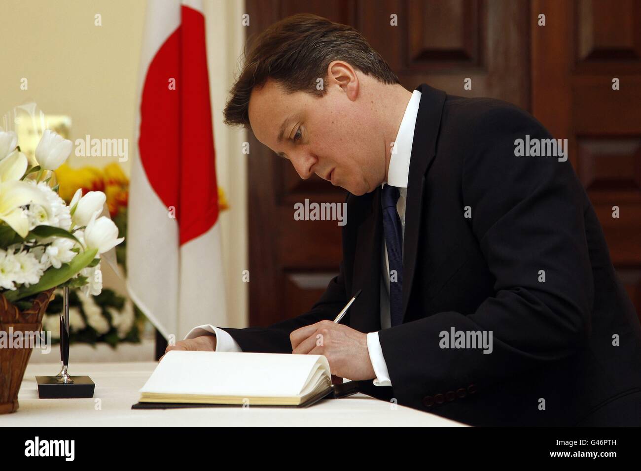 Le Premier ministre David Cameron signe un livre de condoléances à l'ambassade du Japon à Londres. Banque D'Images