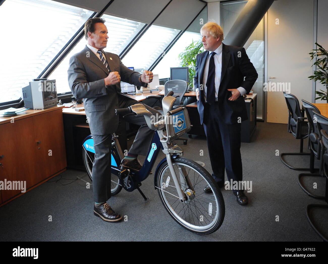 Le maire de Londres Boris Johnson montre à l'ancien gouverneur de Californie Arnold Schwarzenegger (à gauche) l'un de ses « vélos Boris » dans son bureau à l'hôtel de ville de Londres. Banque D'Images