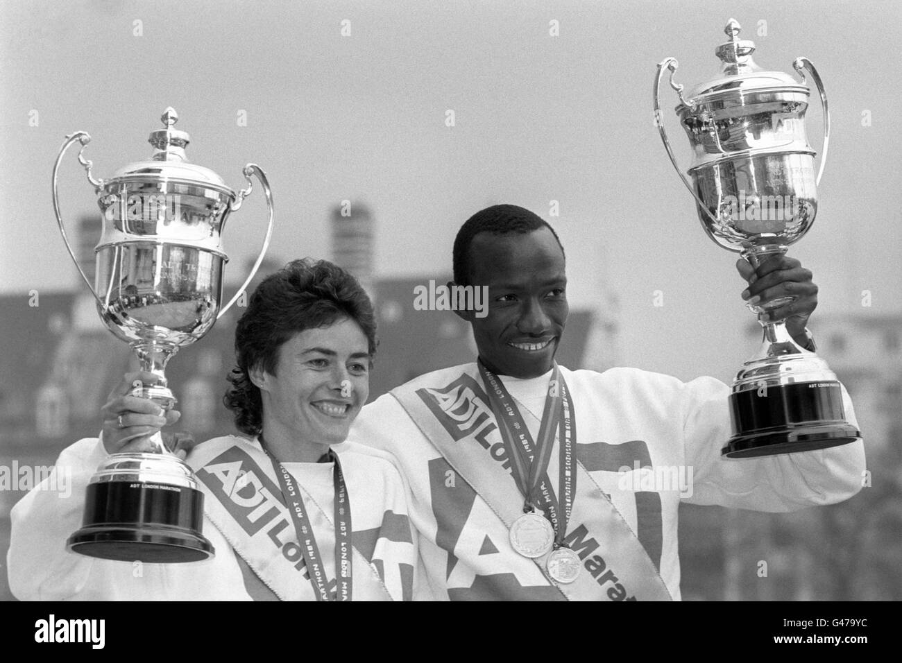 Véronique Marot (l), coureur britannique d'origine française, détient son trophée pour avoir remporté la course d'élite des femmes avec Douglas Wakiihuri (r), gagnant de la course d'élite des hommes. Banque D'Images