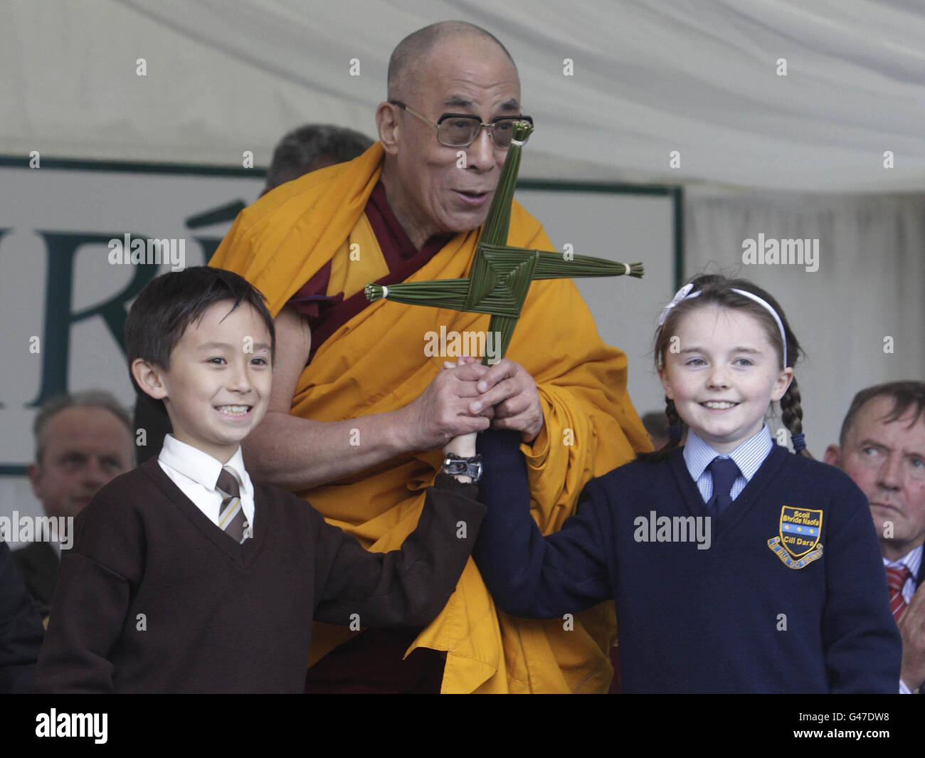 Les écoliers Felim Ayala et Niamh Hopkins présentent le chef spirituel du Tibet, le Dalaï Lama, avec une croix de St Brigi lors de sa visite à Kildare Town à Co Kildare. Banque D'Images