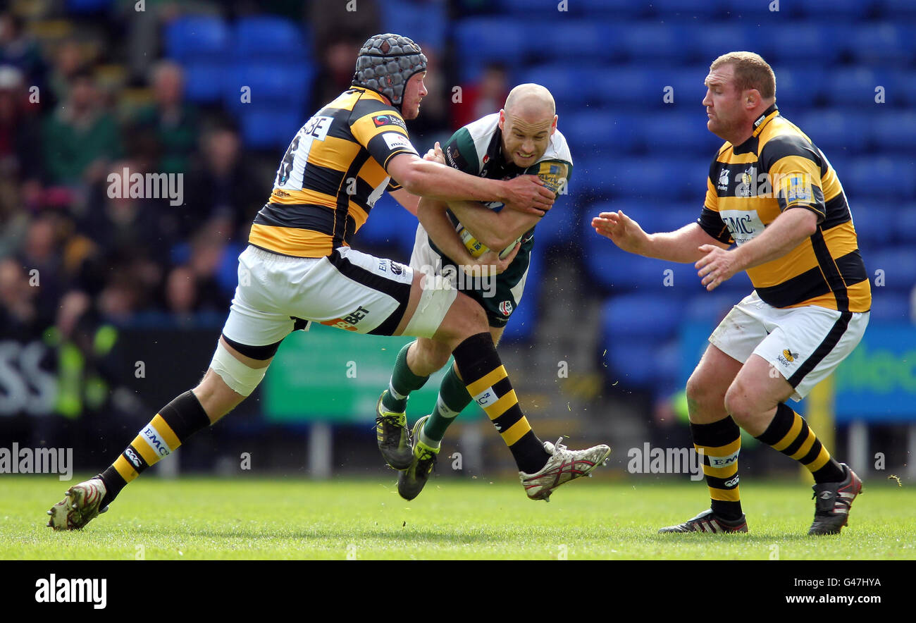 Paul Hodgson (au centre), des Irlandais de Londres, est attaqué par John Hart (à gauche) de Wasps lors du match Aviva Premiership, le Madejski Stadium, Reading. Banque D'Images