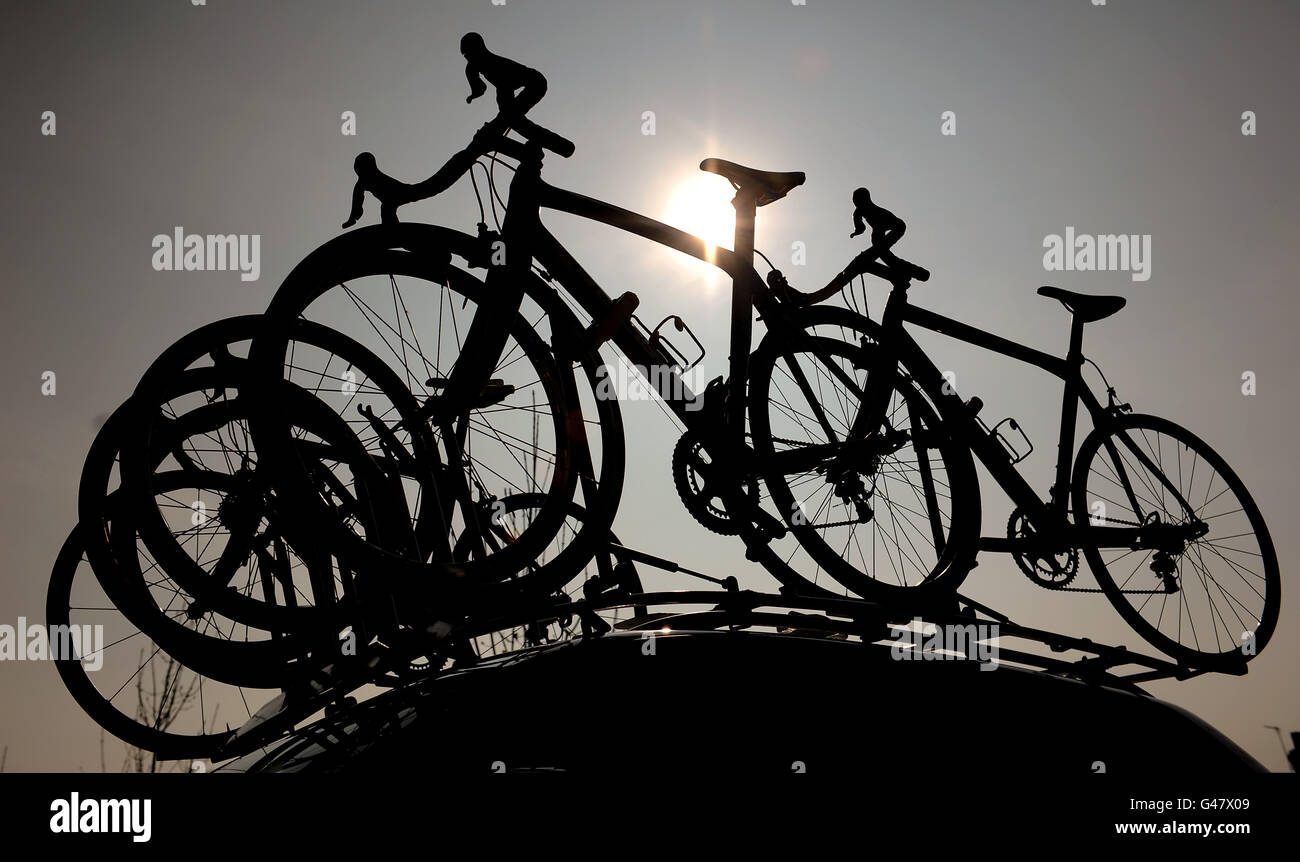 Vue silhouettée d'un certain nombre de motos de course sur le toit d'une voiture de support Banque D'Images