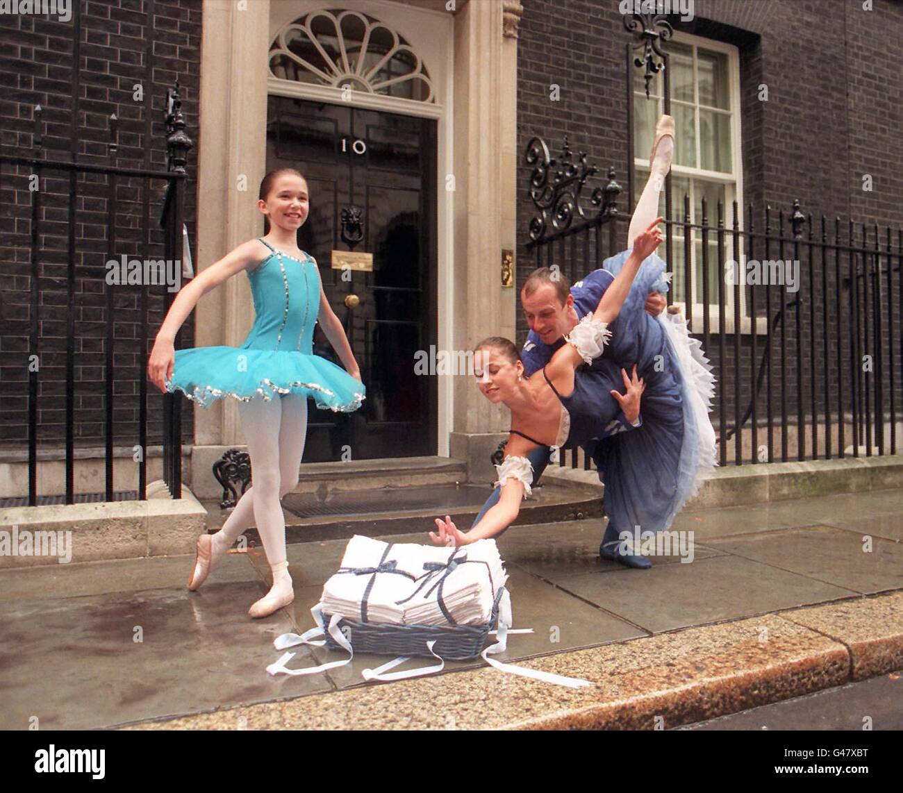 Dancers (de gauche à droite), Kristen McGarrity, Lorna Scott et Preston Clare sourient sous la pluie en donnant l'une des plus importantes performances de leur carrière à l'extérieur du no 10 Downing Street aujourd'hui (lundi) en présentant une pétition signée par 50,000 exhortant Tony Blair à intervenir pour sauver le Ballet écossais, La seule compagnie de danse classique d'Écosse. Elle prendra fin si le Scottish Arts Council soutient une proposition visant à réduire de plus de 500,000 sa subvention annuelle. Voir PA Story ARTS Dance. Photo de David Cheskin/PA Banque D'Images