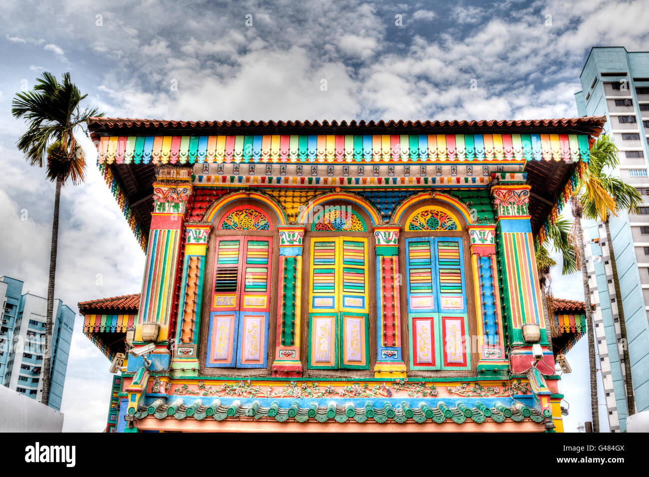 Le rendu HDR d'une façade de bâtiment coloré dans Little India, Singapour, avec de grandes tours d'habitation à l'arrière-plan. Banque D'Images