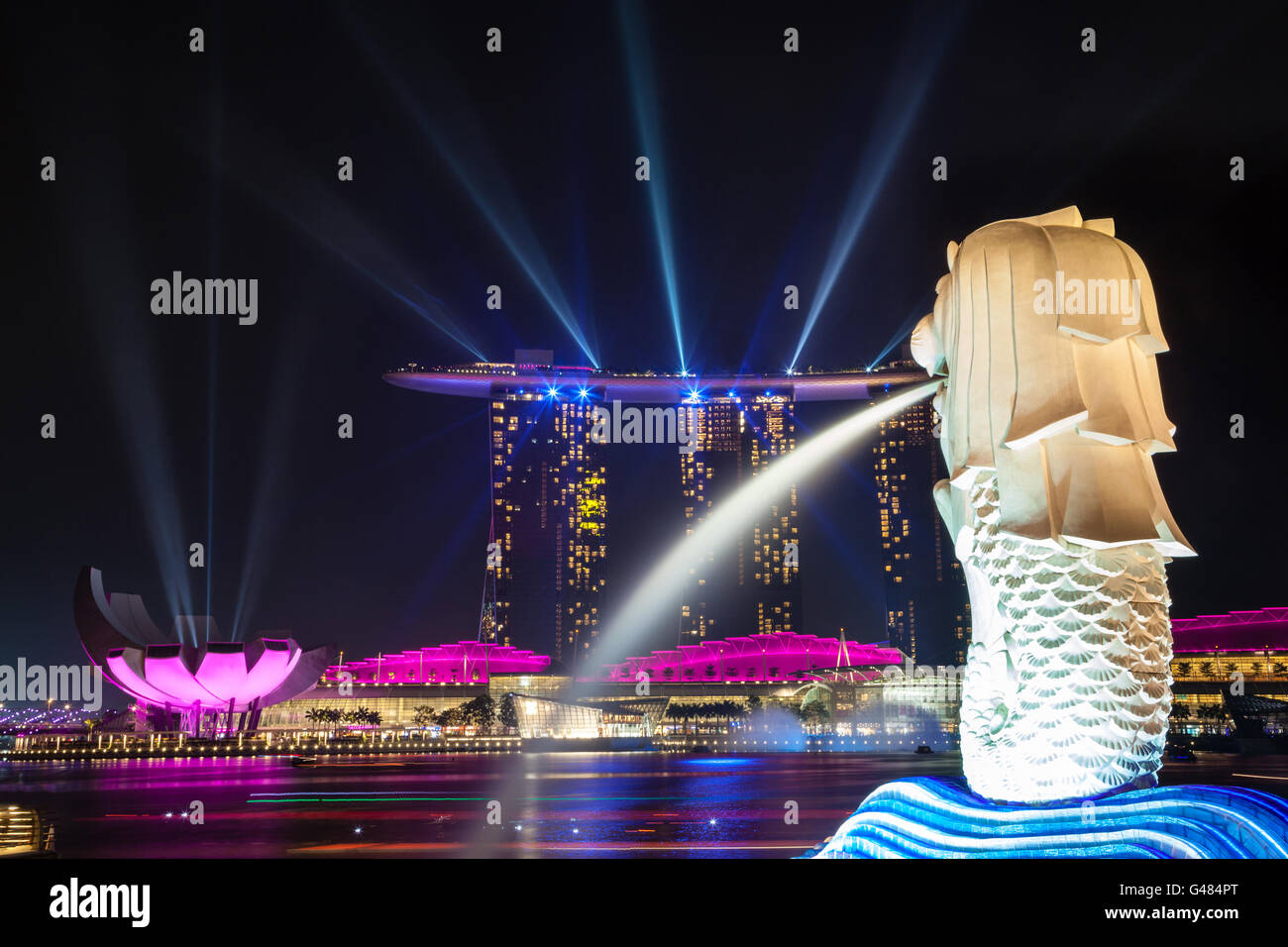Singapour - 3 octobre, 2012 : Singapore's statue Merlion veille sur lumières laser émanant de la Marina Bay Sands Hotel. Banque D'Images