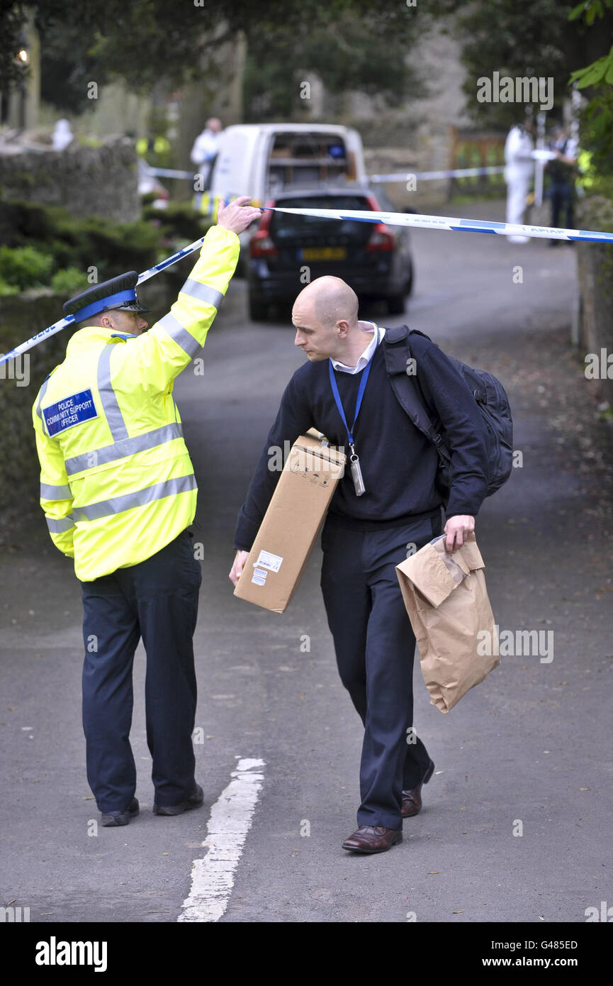 Un homme porte un sac de preuves et une boîte de la scène d'un tir en  double à Westbury-Sub-Mendip, près de Cheddar, Somerset Photo Stock - Alamy