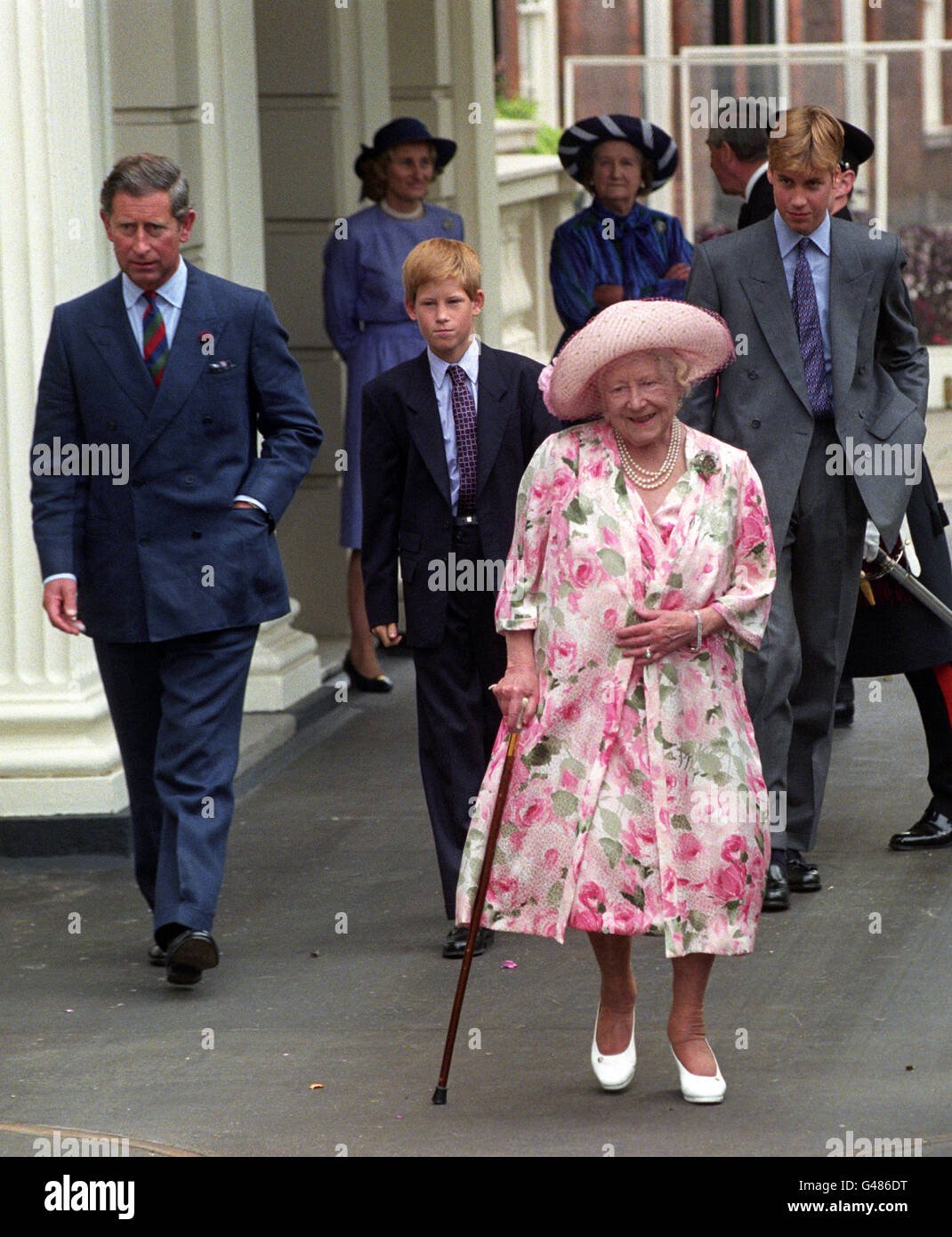 La reine mère accompagnée de son petit-fils, le prince Charles et ses deux fils, le prince Harry (au centre) et le prince William, quitte Clarence House pour rencontrer les milliers de ferrailleurs qui se sont rassemblés à l'extérieur pour souhaiter à leur préféré le 97e anniversaire de leur famille. Banque D'Images