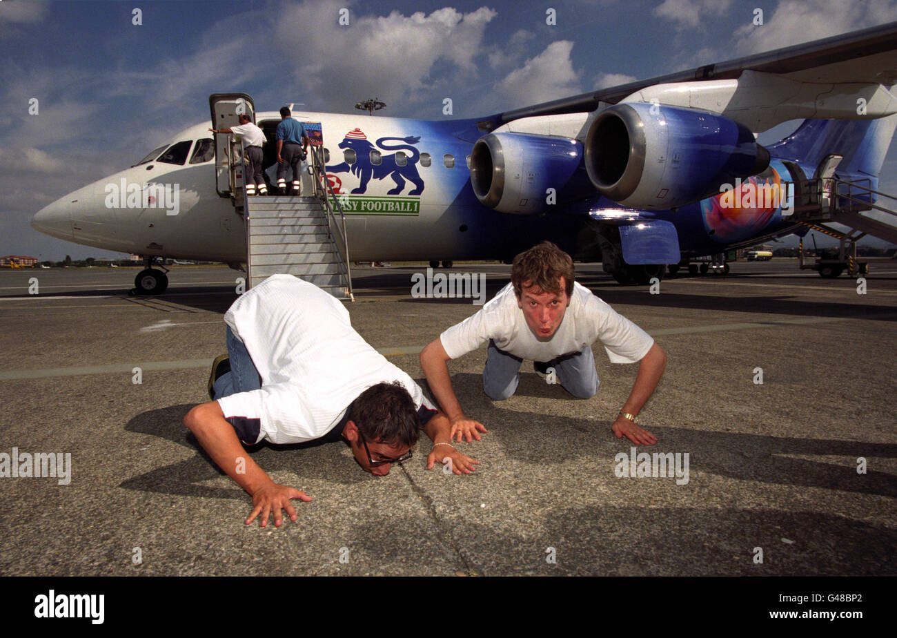 Les bandes dessinées et co-présentateurs de la « Fantasy football League » de la BBC 1, Frank Skinner, Left et David Baddiel baiser le tarmac de l'aéroport Ciampinio de Rome après être arrivé à bord d'un jet spécialement conçu pour assister au tirage de qualification de la coupe du monde d'Angleterre 0-0 contre l'Italie, assurant ainsi l'entrée aux finales 1998.À Rome la nuit dernière (samedi).Photo de Fiona Hanson/PA. Banque D'Images