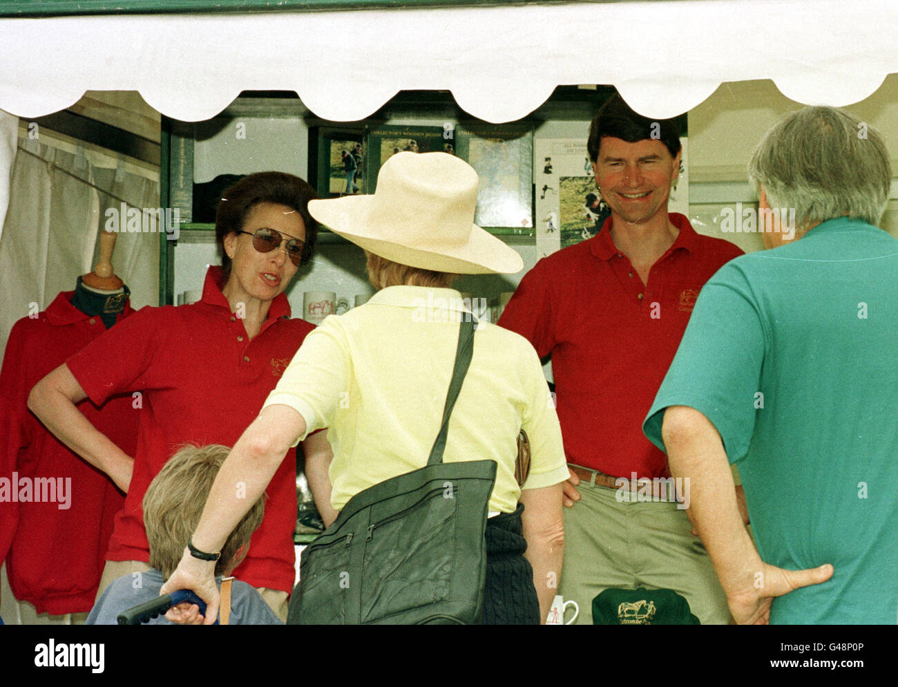 La princesse Anne (L) parle à un client dans la boutique de Gatcombe lors de l'Assemblée horse trials, tandis que son mari Tim Laurence regarde sur. Banque D'Images