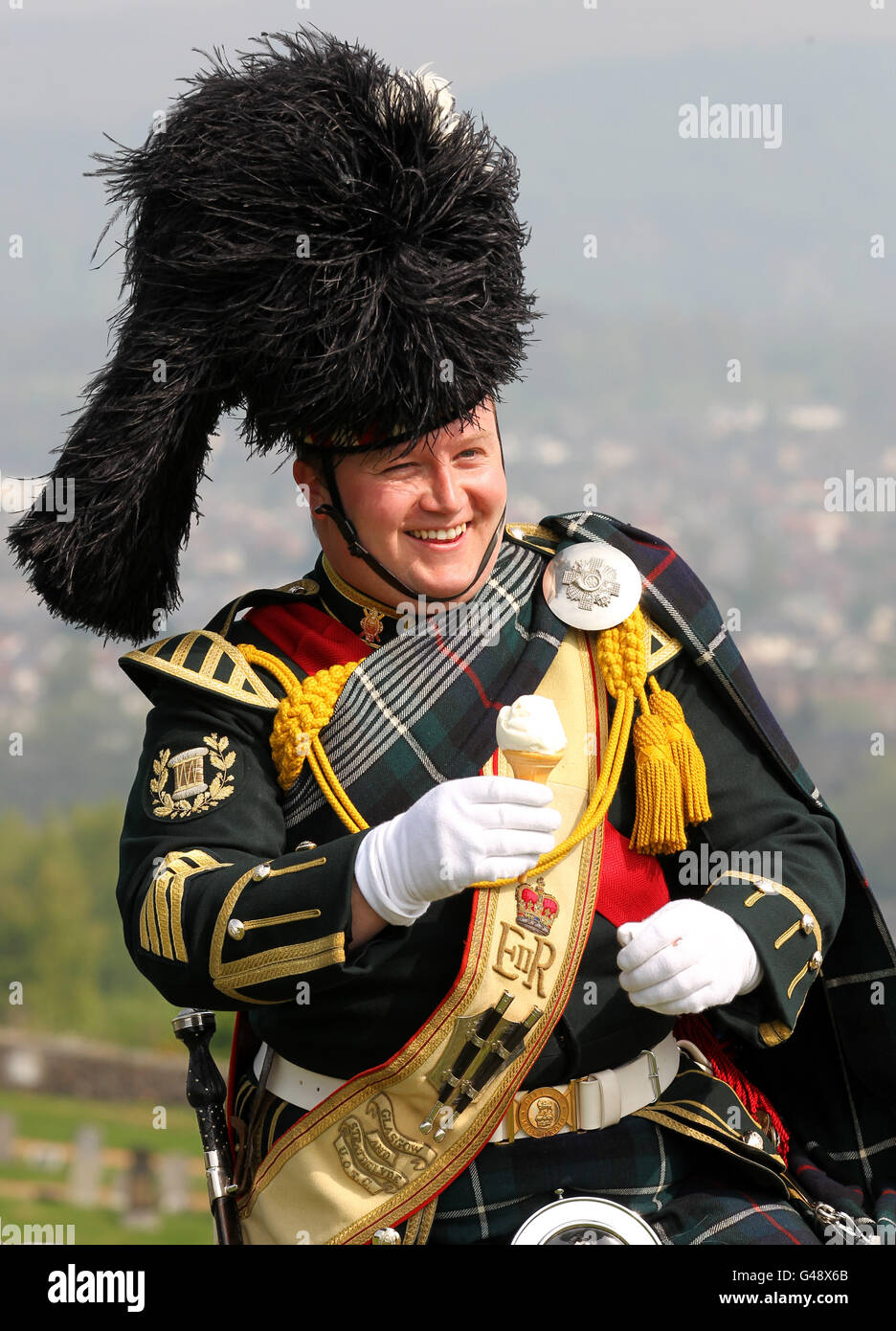 Le Pipe Major Kenny Stoddart, du Pipes and Drums du corps de formation des officiers des universités de Glasgow et Strathclyde, mange une glace après un hommage de 21 armes à feu pour souligner le 85e anniversaire de la reine au château de Stirling. Banque D'Images