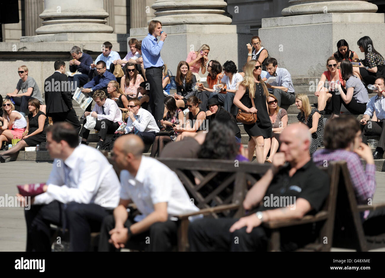 Les employés de la ville apprécient le soleil du déjeuner à l'extérieur de la Bank of England, Londres, tandis que les amateurs de soleil ont profité du jour le plus chaud de l'année jusqu'à présent - et le temps anormalement chaud est prévu pour se poursuivre le week-end de Pâques. Banque D'Images