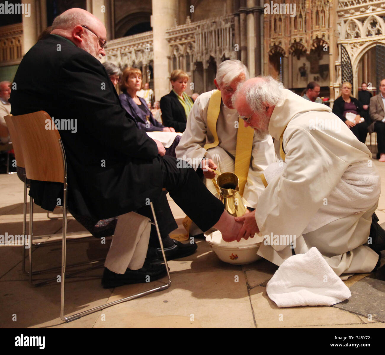 L'archevêque de Canterbury Dr. Rowan Williams (à droite) exécute la cérémonie de lavage des pieds pendant le service de jeudi Maundy à la cathédrale de Canterbury dans le Kent. Banque D'Images