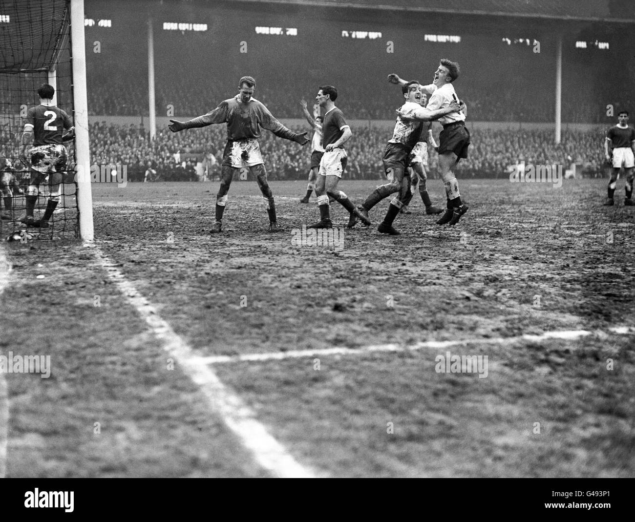 Terry Dyson et Dave Mackay étreinte après que Dave Mackay a marqué le troisième but de Tottenham Hotspur comme le gardien de but de Crewe Alexandra Brian Williamson et le coéquipier Eric Barnes ne peuvent que regarder sur abattu. Banque D'Images