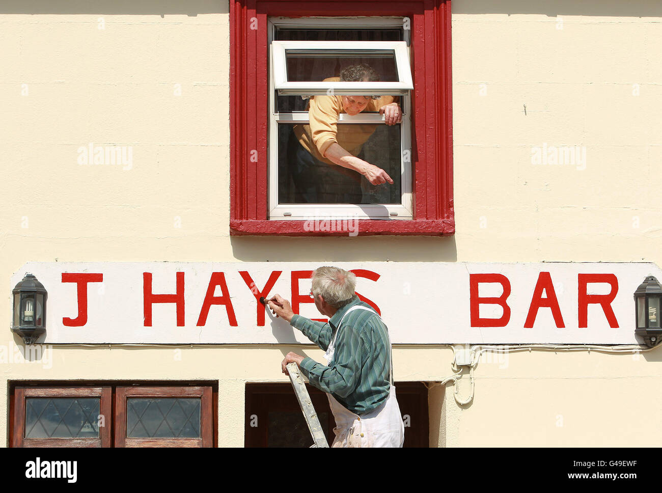 La locale Julia Hayes dirige Patrick Hayes où peindre de sa chambre à Moneygall, Co Offaly, alors que la fièvre d'Obama balaye le village avec des locaux réparant des trottoirs et peignant des maisons avant l'arrivée du président Barack Obama plus tard ce mois-ci. Banque D'Images