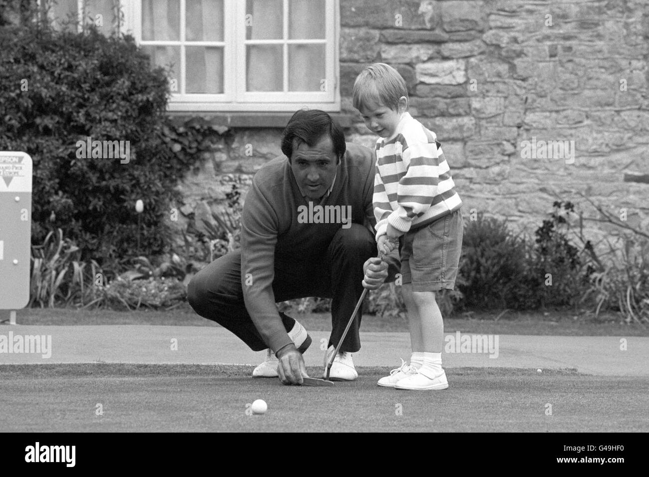 Le favori d'Epson Matchplay, Seve Ballesteros, donne à Andrew Mason, quatre ans, fils du golfeur anglais Chris Mason, une leçon de mise au club de golf St Pierre, Chepstow avant le tournoi Pro-Am. Banque D'Images