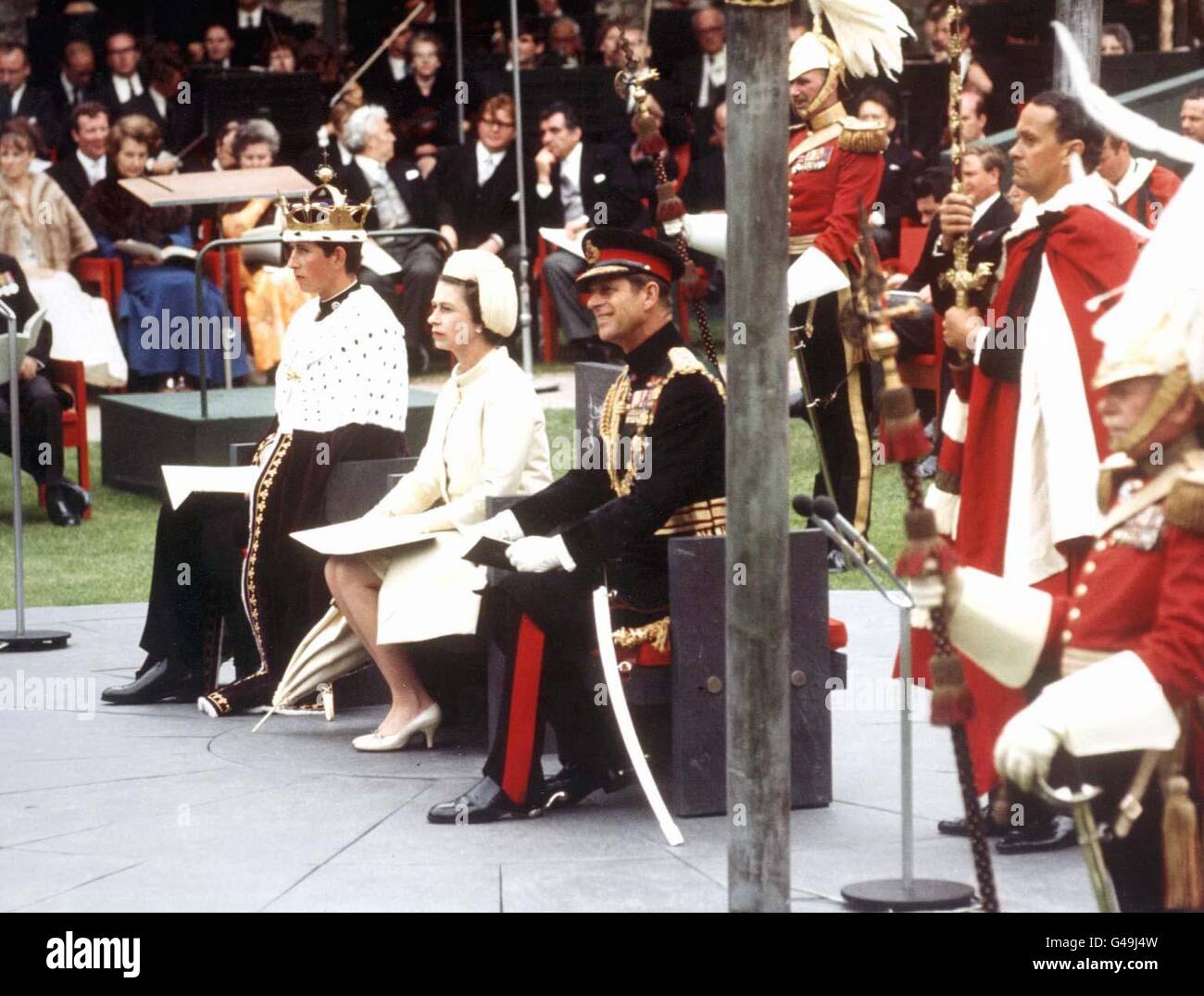 La Reine (au centre) son fils le prince Charles (à gauche) et son mari le duc d'Édimbourg lors de la cérémonie d'investiture du prince Charles en tant que prince de Galles au château de Caernarfon. Banque D'Images
