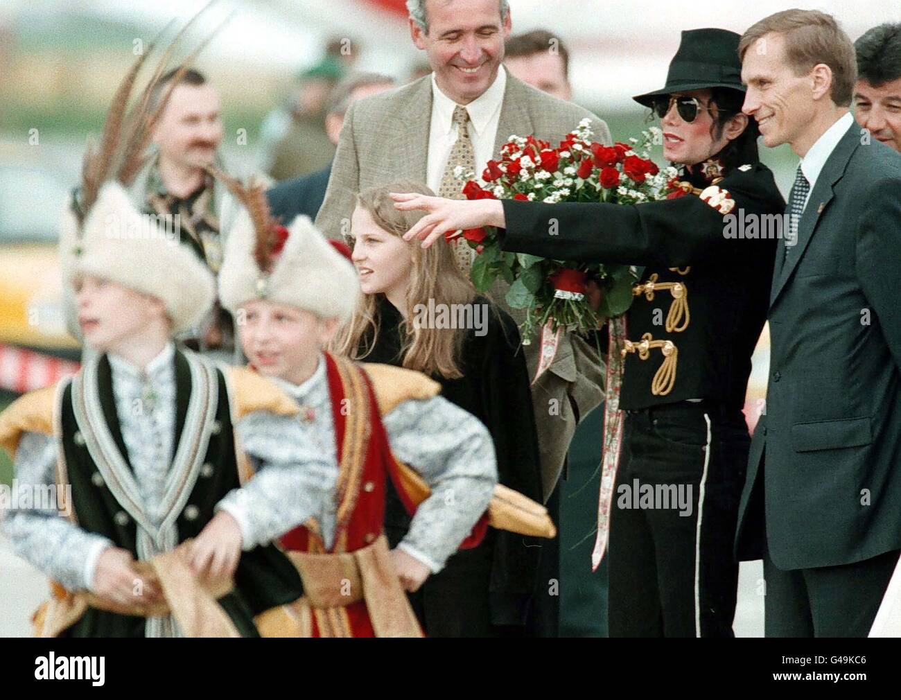 Pop star US Michael Jackson (2e r) est accueilli par le maire de Varsovie Marcin Swiecicki (r) pendant qu'il observe un groupe folklorique polonais à l'aéroport militaire de Varsovie 27 mai à son arrivée pour une visite de deux jours, auraient été intéressés par l'achat d'un château. Trois ont été proposées, l'une près de Wroclav et deux au sud de Varsovie. Banque D'Images