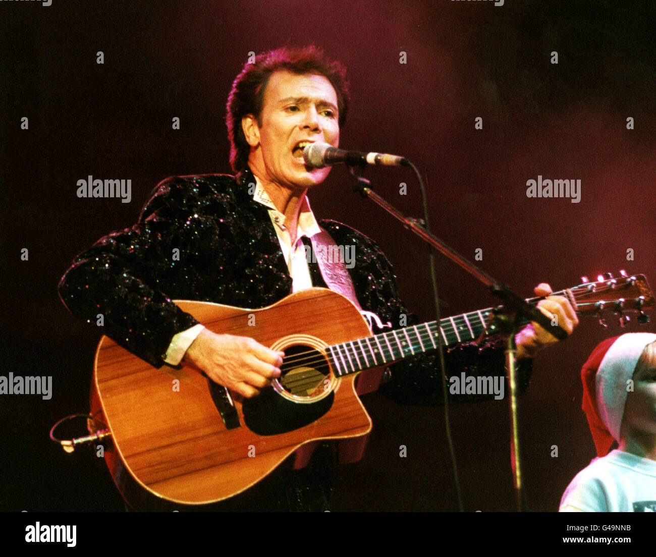 PA NEWS PHOTO 9/12/97 LE CHANTEUR CLIFF RICHARD SE PRODUIT LORS DU CONCERT DE NOËL DE HALLELUJAH AU LONDON ARENA. L'ORGANISME DE BIENFAISANCE RECUEILLE DES FONDS ET SENSIBILISE LES ENFANTS EN CRISE ET AIDE ET AIDE LES ENFANTS OUBLIÉS DANS DE NOMBREUSES RÉGIONS DU MONDE. Banque D'Images