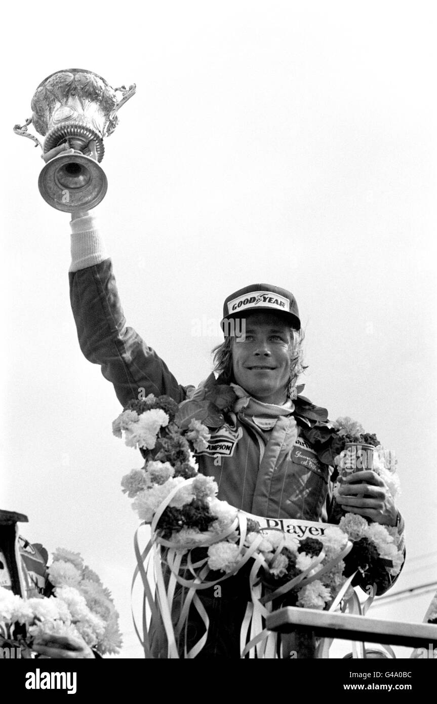 James Hunt de Grande-Bretagne avec le trophée des gagnants après avoir remporté le John Player Grand Prix britannique à Silverstone dans sa McLaren Banque D'Images