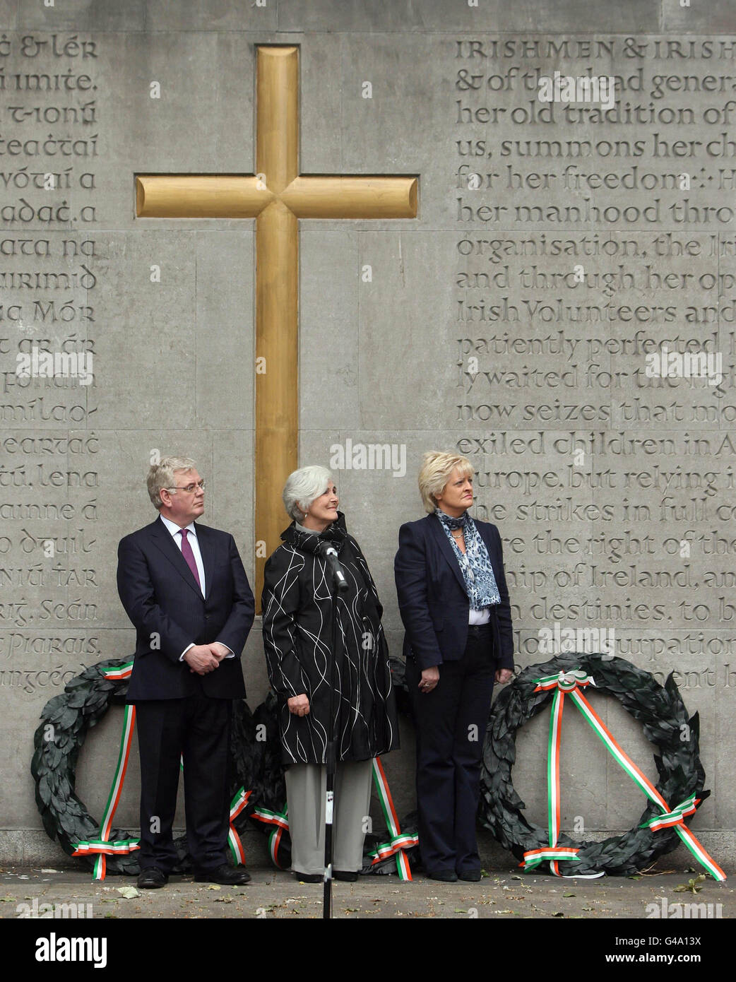 (Gauche - droite) Tanaiste Eamon Gilmore, Maggi Connolly, petite-fille de James Connolly, Patricia King du Congrès irlandais des syndicats, regarde le drapeau national qui est élevé lors de la commémoration annuelle de James Connolly au cimetière militaire d'Arbour Hill, à Dublin. Banque D'Images