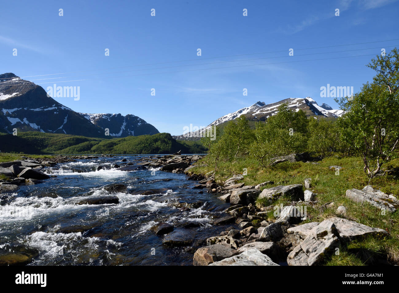 Peu de flux avec les montagnes enneigées en arrière-plan, photo du nord de la Norvège. Banque D'Images