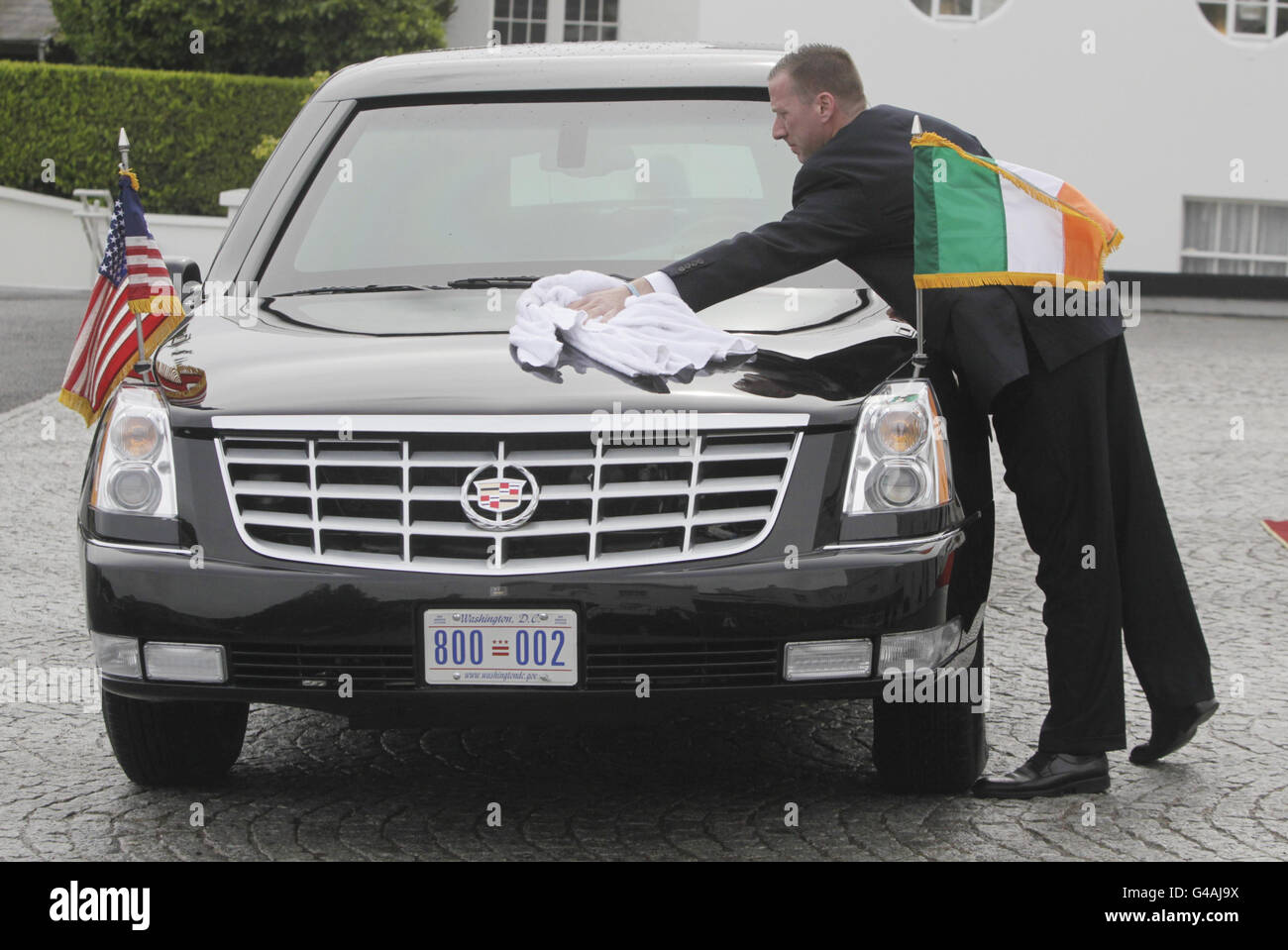 Un agent de service secret nettoie l'eau de pluie de la voiture présidentielle alors que le président Barack Obama et la première dame Michelle Obama rencontrent la présidente Mary McAleese et son mari Martin à Aras an Uachtarain Phoenix Park, avant d'assister à une cérémonie de plantation d'arbres dans son domaine, Au cours de sa visite en Irlande, au début d'une visite d'une semaine en Europe. Banque D'Images