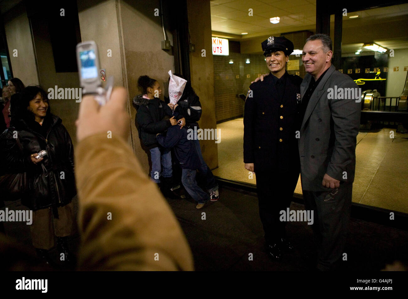 29 décembre 2005 - New York, NY - un agent de police nouvellement assermenté pose avec un membre de la famille pour une photo après graduat Banque D'Images