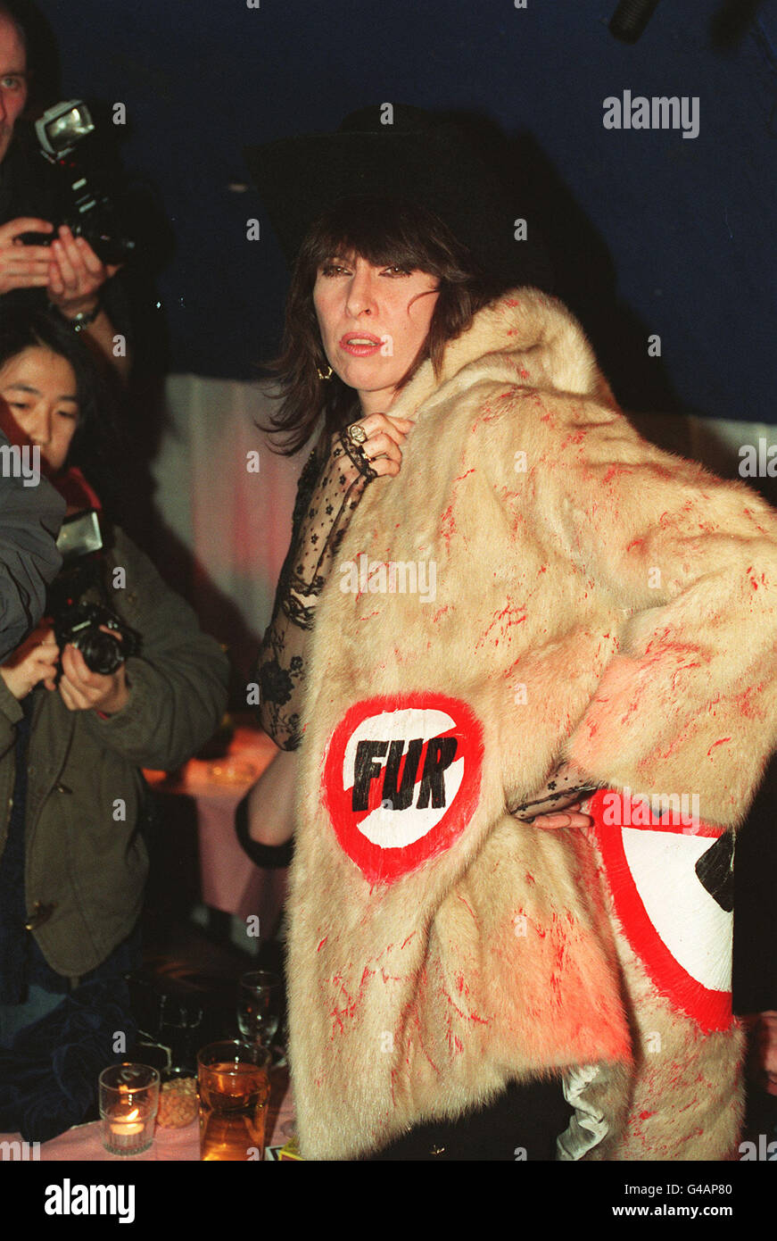 PA NEWS PHOTO 14/03/93 CHRISSIE HYNDE AMERICAN SINGER MODELS A FOURRURE D'OCCASION ÉCLABOUSSÉ DE PEINTURE ROUGE PENDANT LE LANCEMENT DE PERSONNES PETA POUR LE TRAITEMENT ÉTHIQUE DES ANIMAUX À DISCOTHÈQUE « LE PARADIS » DE LONDRES Banque D'Images