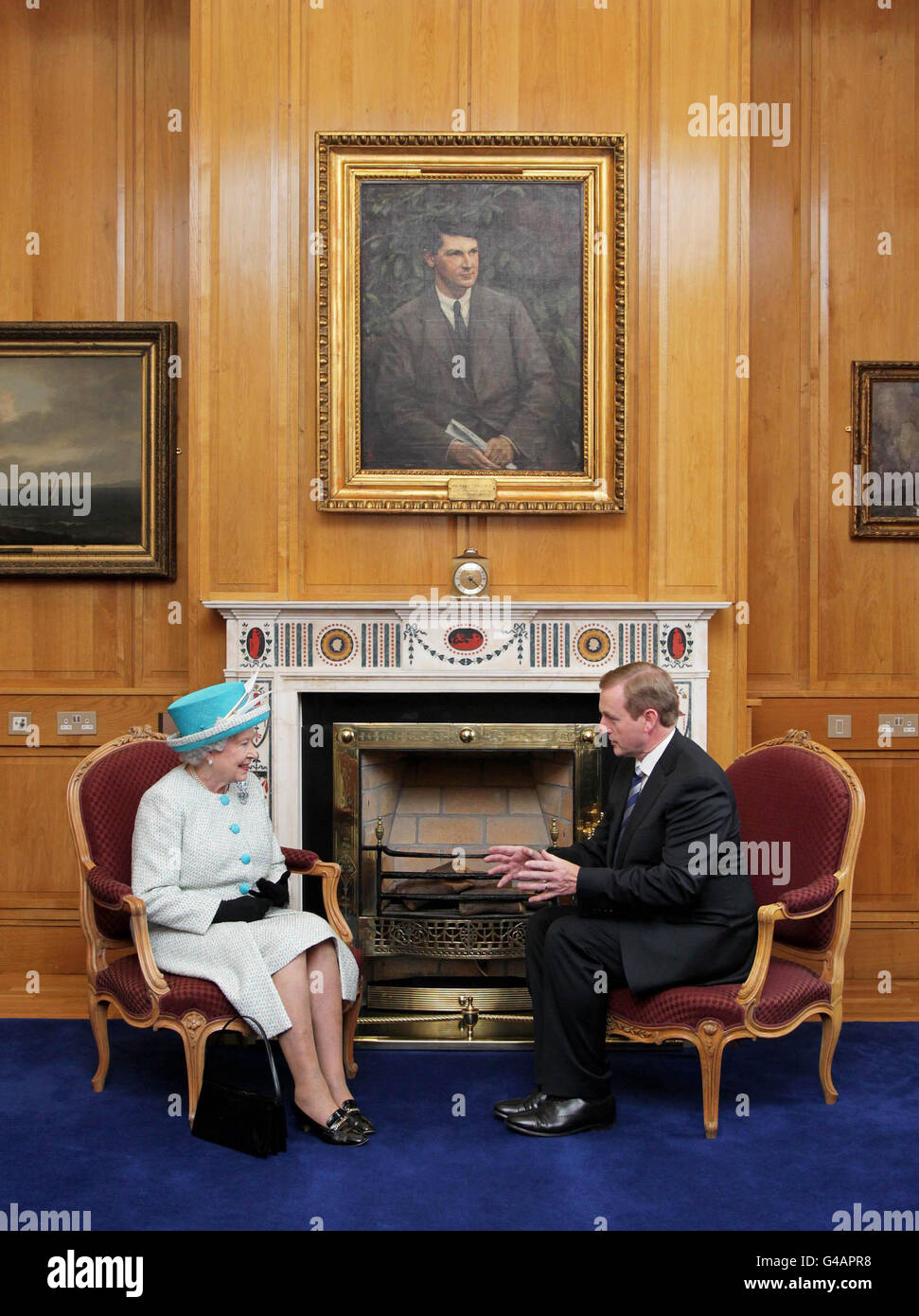 La reine Elizabeth II et Taoiseach Enda Kenny parlent dans son bureau, alors qu'ils sont assis sous un portrait de Michael Collins, dans les édifices gouvernementaux de Dublin, au cours de la deuxième journée de sa visite d'État en Irlande. Banque D'Images