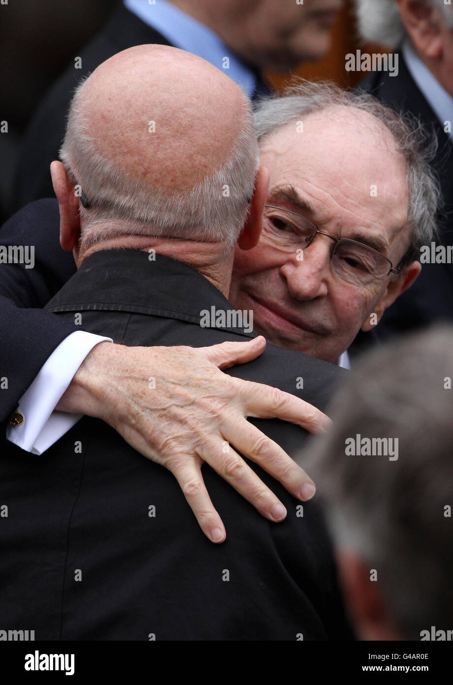 Cliff Morgan (à droite) déchire Sir Bobby Charlton alors qu'ils quittent l'église catholique de Corpus Christi à Tonbridge, dans le Kent, à la suite des funérailles du boxeur Sir Henry Cooper. Banque D'Images