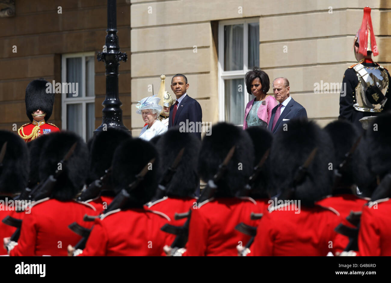 LE président AMÉRICAIN Barack Obama et la première dame Michelle Obama regardent la garde d'honneur du 1er bataillon Scots Guards, lors de l'accueil cérémonial par la reine Elizabeth II et le duc d'Édimbourg dans le jardin du Palais de Buckingham dans le cadre de la visite d'État d'Obama au Royaume-Uni et en Irlande. Banque D'Images