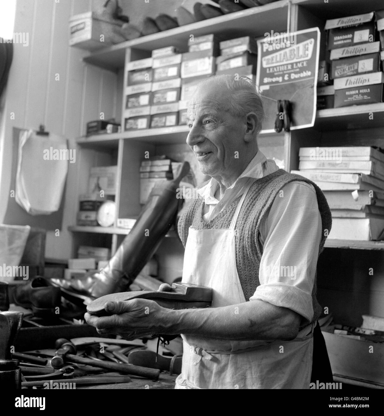 M. W.G Yerbury, 83 ans, un cobbler encore en activité à Dulverton, Somerset. Un jeune Barnado original, il a été trouvé dans une rue de Londres par le Dr Thomas Barnado et emmené à la maison d'origine à Stepney Causeway, où il a grandi et a finalement appris le métier de fabrication de bottes. Banque D'Images