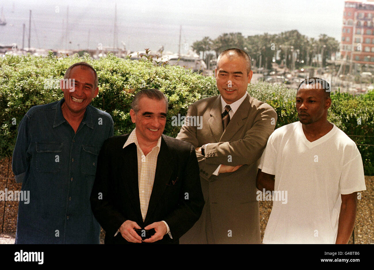 Président du 51e jury du Festival de Cannes, le réalisateur Martin Scorsese, est accompagné des membres masculins du jury sur le toit du Palais des Festivals, à Cannes, France, avant la première du film d'ouverture, Primary Colors. * (de gauche à droite) Alain Corneau, Martin Scorcese, Chen Kaige et MC Solaar. Banque D'Images