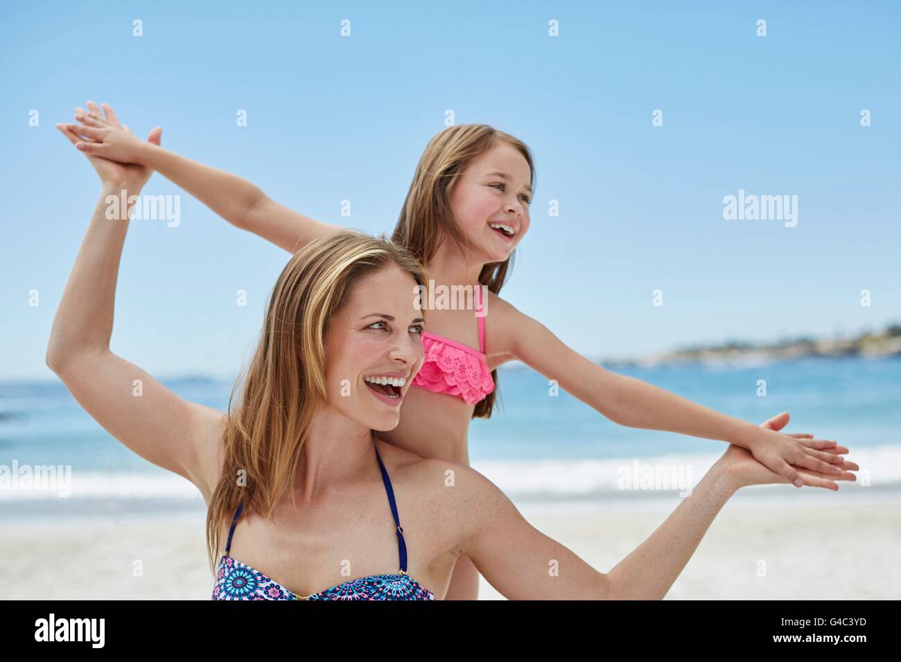 Parution du modèle. Mère et fille sur la plage avec les bras, portrait. Banque D'Images