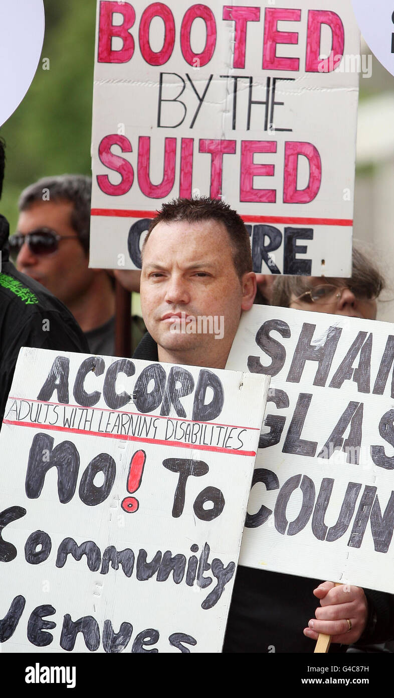 Les membres de l'Alliance anti-coupes écossaise protestent devant le Parlement écossais, en appelant le gouvernement écossais à ne pas appliquer les réductions de dépenses de Westminster. Banque D'Images