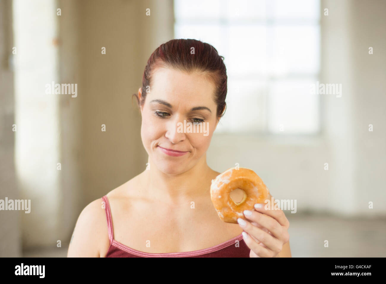 Femme se sentir coupable de manger des beignes Banque D'Images