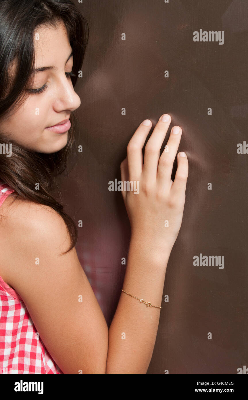 Triste fille main toucher wall Banque D'Images